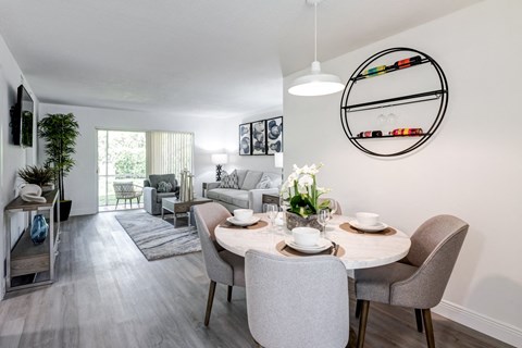 a living room and dining room with a table and chairs